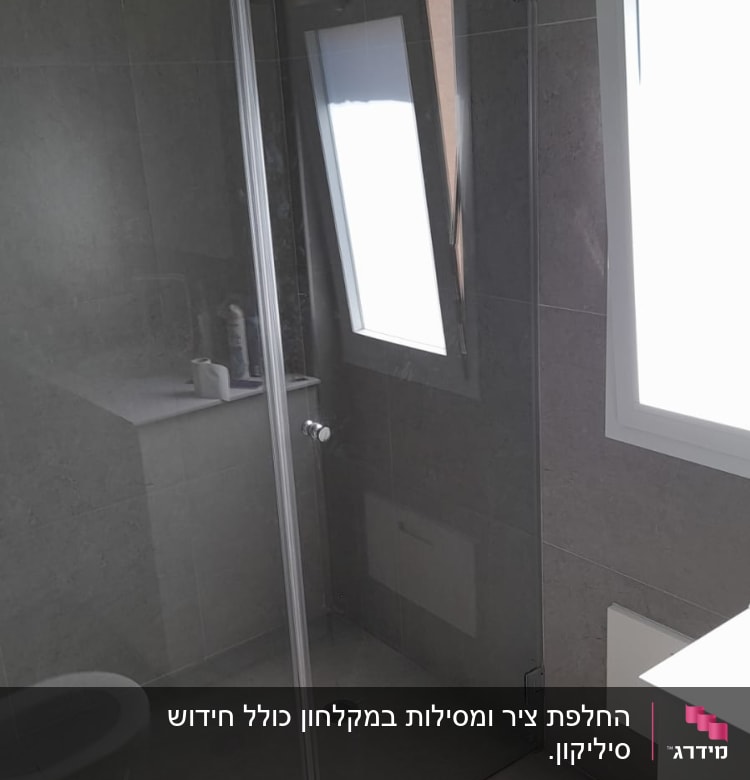 מקלחון זכוכית עם ראש מקלחת עגול ומדף מוצרים
